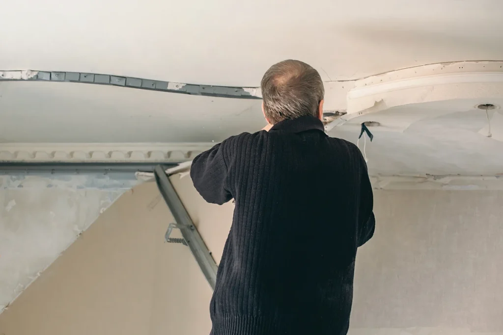 Un homme qui regarde une fissure au plafond