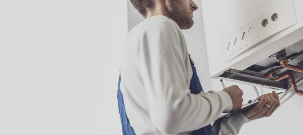 Un homme qui vérifie une chaudière à gaz avant le déplacement