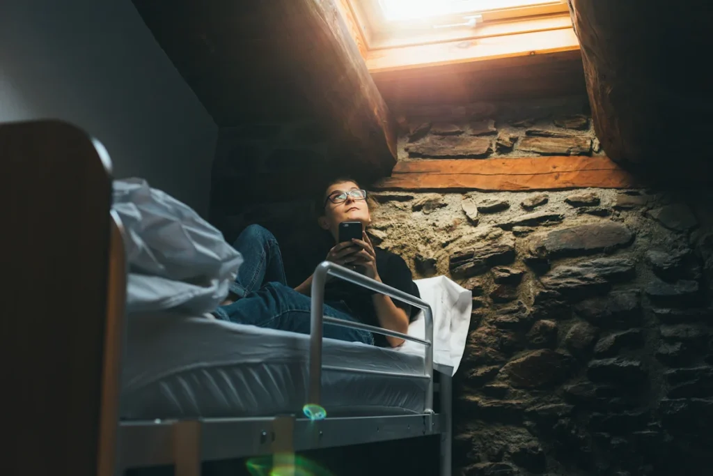 Un jeune homme dans son lit qui lève les yeux vers le plafond